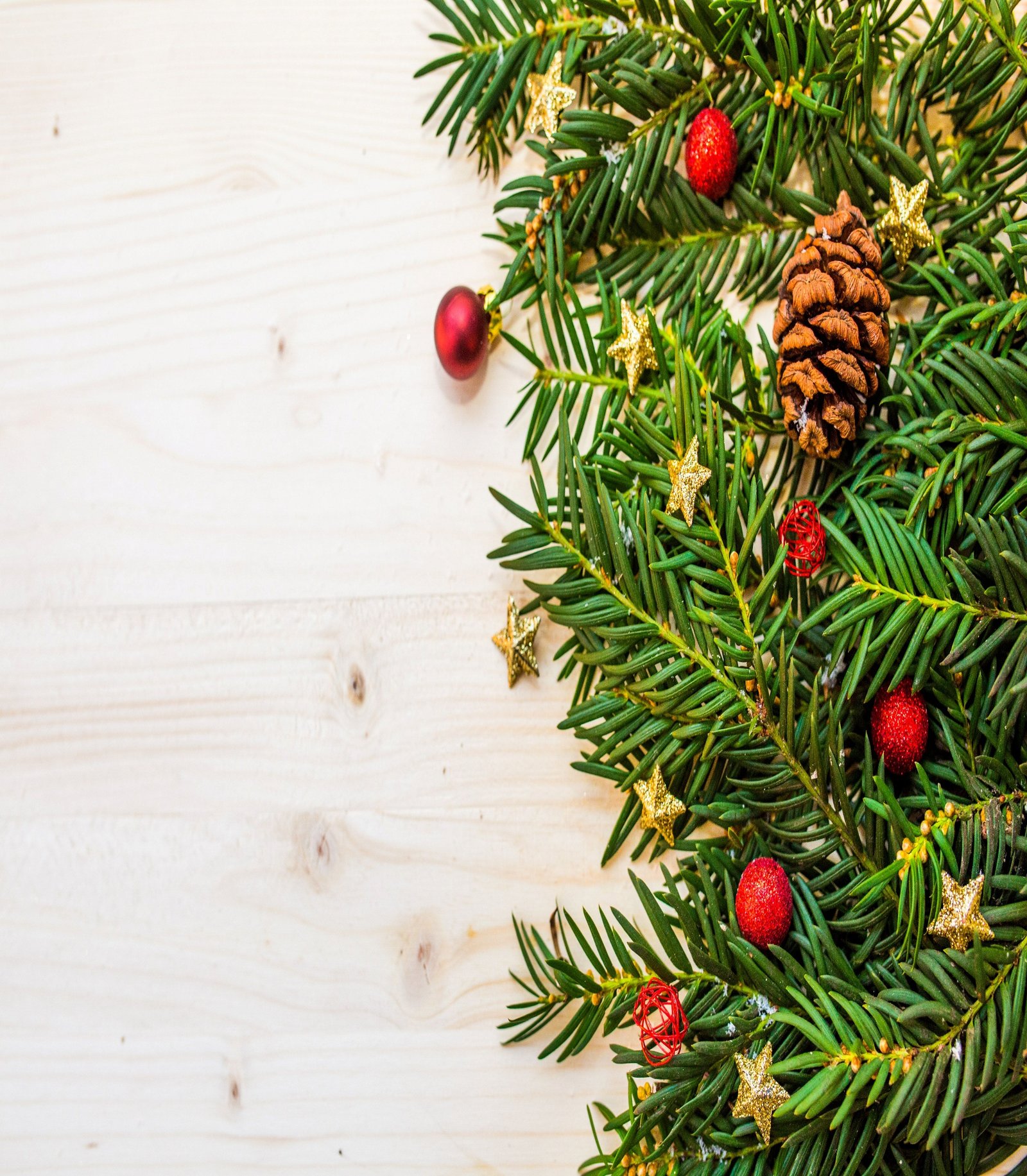 Christmas tree foliage with pine cones, gold stars and red ornaments